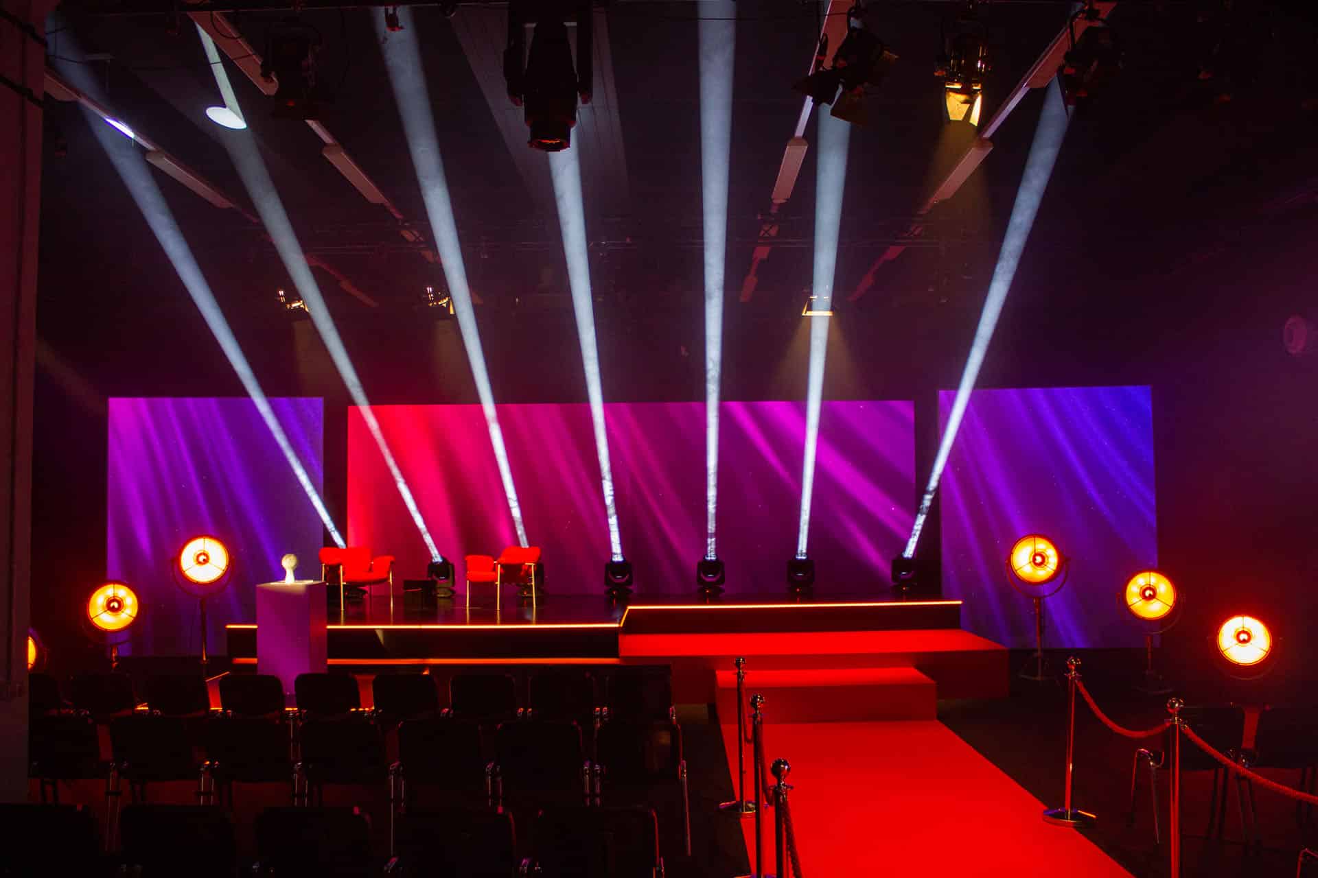 Eine mehrstufige Bühne mit LED Kante, Scheinwerfern und drei Separierter LED Wände