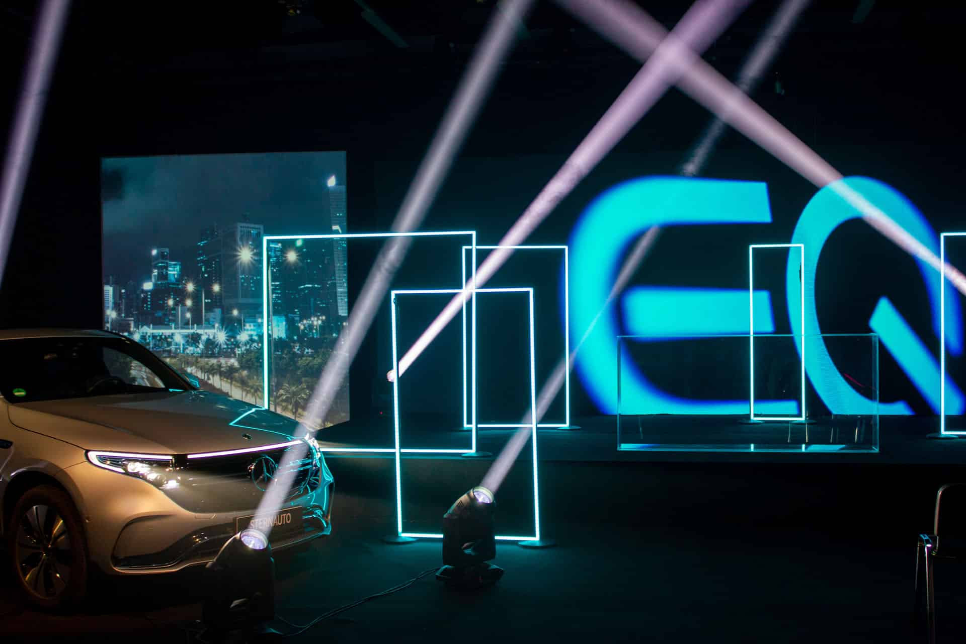 Ein Auto wird mit stielvoll betonenden Licht Effekten vor einer Bühne präsentiert