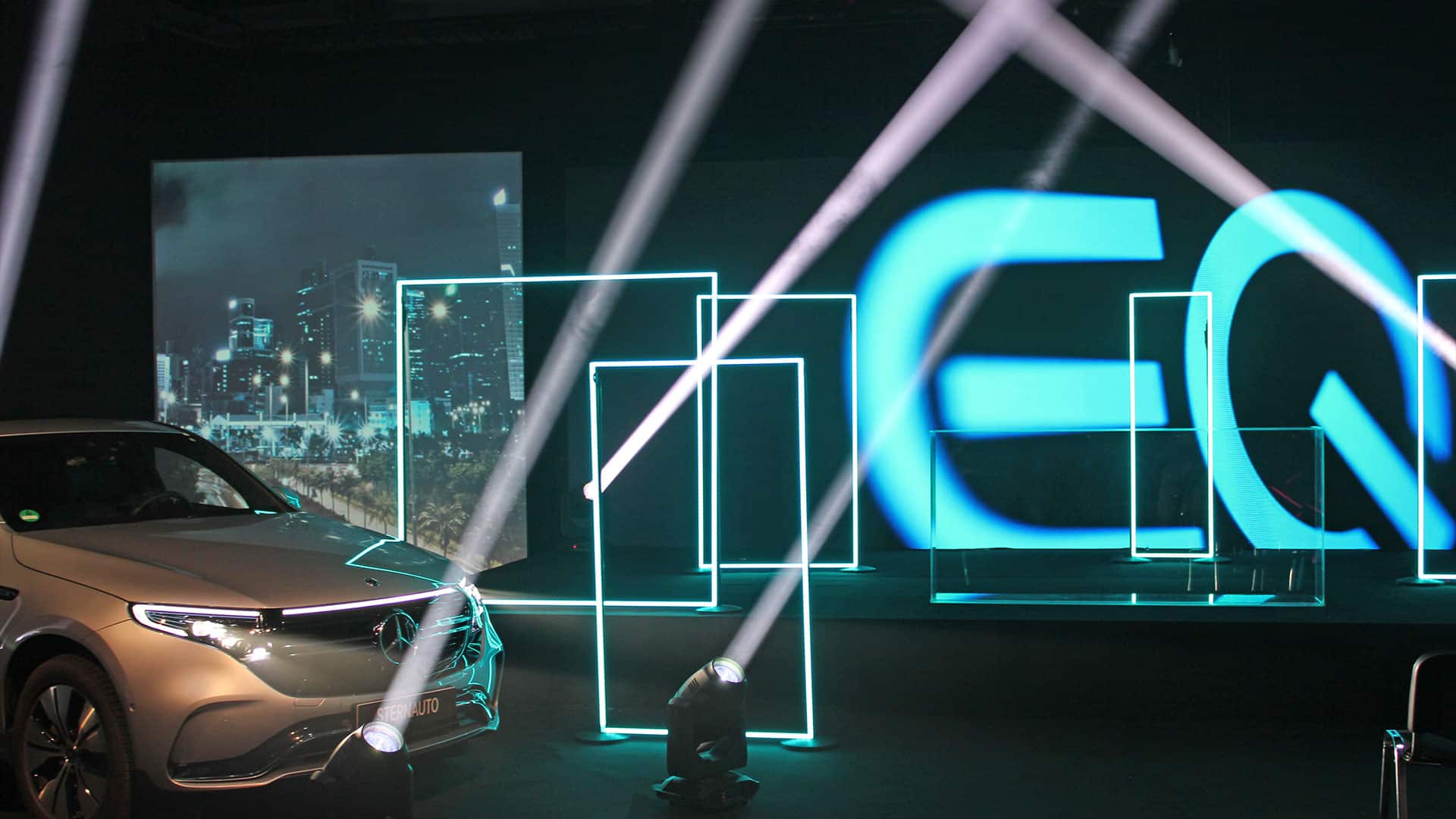 Ein Auto wird mit stielvoll betonenden Licht Effekten vor einer Bühne präsentiert