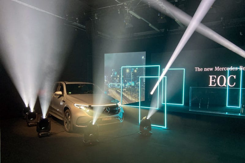 Ein Auto wird vor einer Bühne, durch Licht, in Szene gesetzt . Hinter der Bühne steht eine LED-Wand